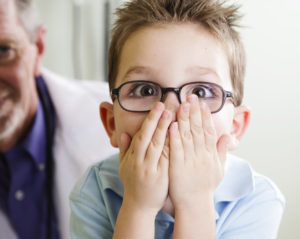 Boy covers his mouth after learning about gum disease in kids