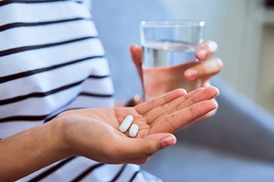 Patient taking pain reliver after tooth extraction in West Brookfield