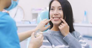 Patient pointing to her gums during dental checkup