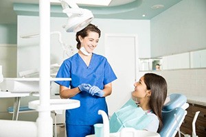Orthodontic assistant talking to teenage patient with braces