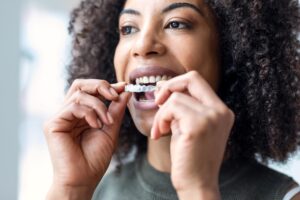 Woman putting on clear aligner