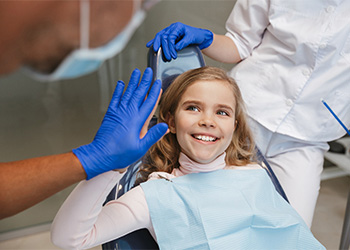 Child smiling and giving dentist a high five