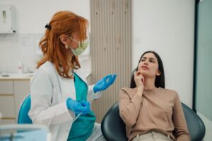 a patient with a concerned expression chatting with their dentist